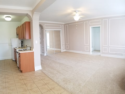 an empty kitchen and living room with a tile floor